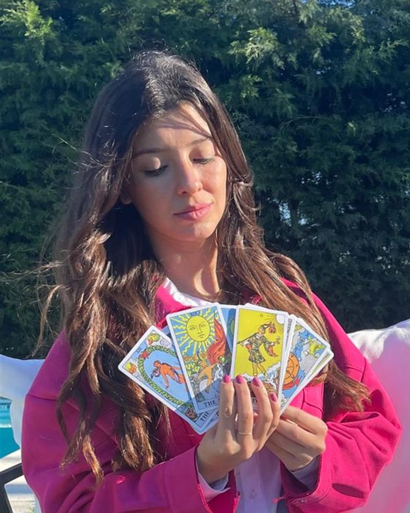 Maria Luján Medone sosteniendo en abanico las cartas de tarot con las que realiza la lectura